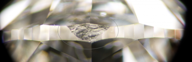 Indented Natural Inclusion Along the Girdle Indented natural inclusion along the girdle edge of a diamond, visible as a rough patch left from the original crystal surface.