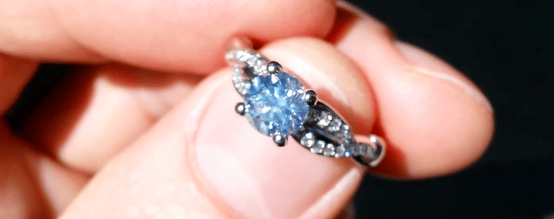 My J color diamond glowing with strong blue fluorescence Round brilliant 0.8 carat J color diamond with strong blue fluorescence glowing in sunlight